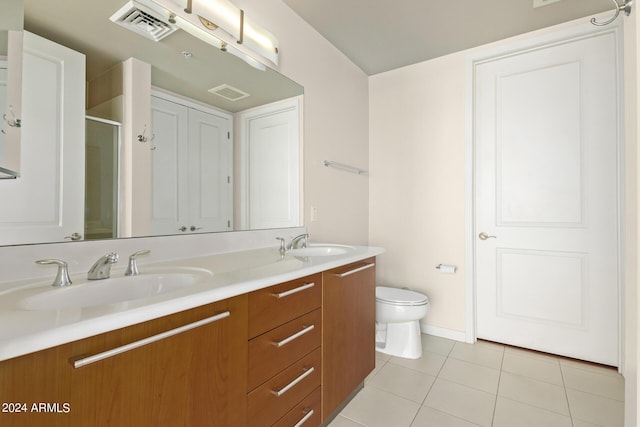 bathroom with tile patterned flooring, vanity, toilet, and walk in shower