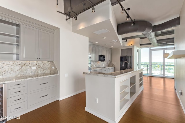 kitchen featuring tasteful backsplash, wood-type flooring, wine cooler, black appliances, and light stone countertops