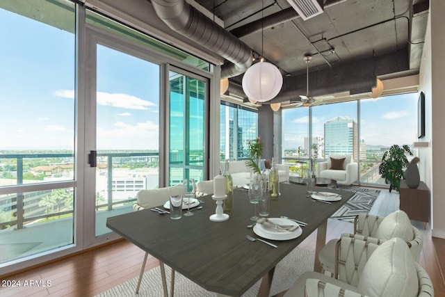 dining area featuring a wall of windows, plenty of natural light, and hardwood / wood-style floors