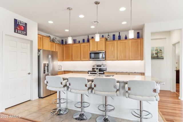 kitchen with visible vents, recessed lighting, appliances with stainless steel finishes, and a kitchen bar