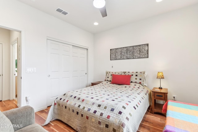 bedroom with recessed lighting, visible vents, a closet, and wood finished floors