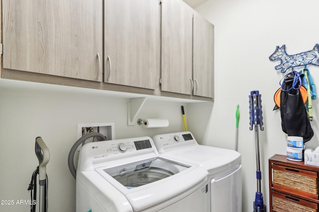 washroom featuring cabinet space and separate washer and dryer