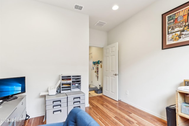 office space featuring light wood-style floors, visible vents, and baseboards