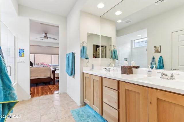 full bath featuring tile patterned flooring, a shower stall, connected bathroom, and a sink