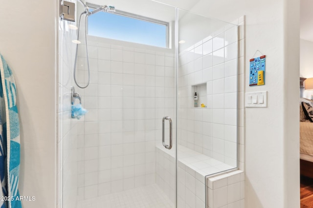 bathroom featuring connected bathroom and a shower stall