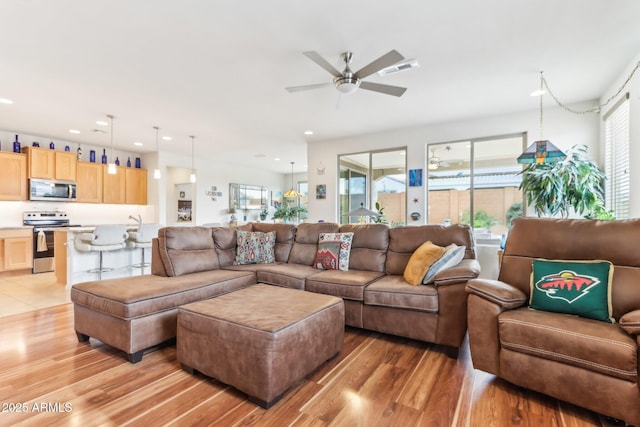 living area featuring recessed lighting, visible vents, light wood-style flooring, and ceiling fan