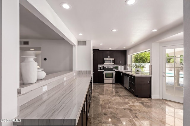 6119 E Sandra Ter, Scottsdale, AZ 85254 - kitchen featuring stainless steel appliances, a sink, recessed lighting, tasteful backsplash, and dark brown cabinets
