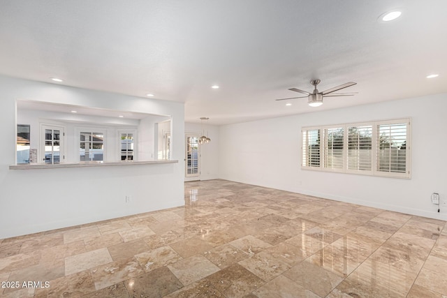 6119 E Sandra Ter, Scottsdale, AZ 85254 - unfurnished living room with recessed lighting, stone tile floors, a ceiling fan, and a chandelier