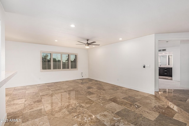 6119 E Sandra Ter, Scottsdale, AZ 85254 - spare room featuring stone tile floors, ceiling fan, recessed lighting, and baseboards