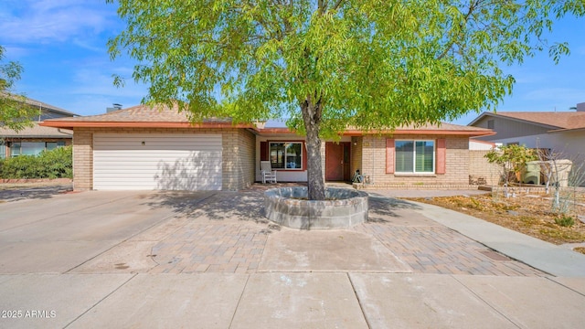 ranch-style home featuring brick siding, driveway, and an attached garage