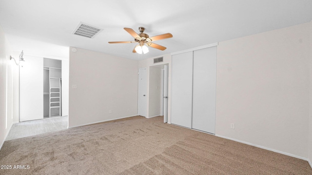 unfurnished bedroom with visible vents, a ceiling fan, and light colored carpet