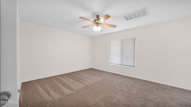 empty room featuring ceiling fan, carpet flooring, visible vents, and baseboards