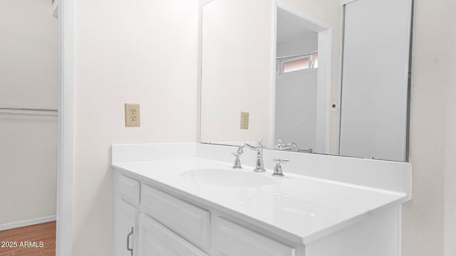 bathroom with wood finished floors, vanity, and baseboards