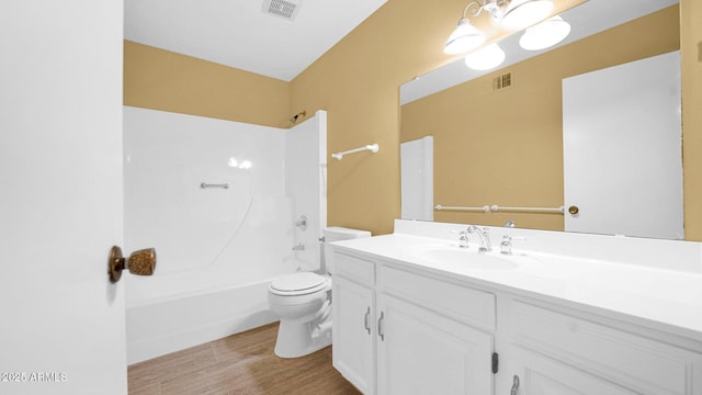 bathroom featuring wood finished floors, visible vents, toilet, and tub / shower combination