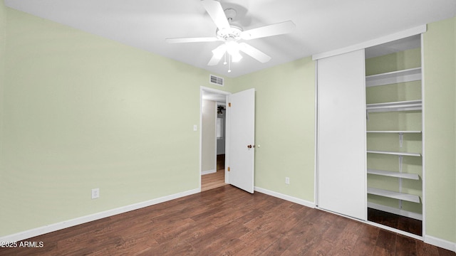 unfurnished bedroom with baseboards, visible vents, dark wood finished floors, and a closet