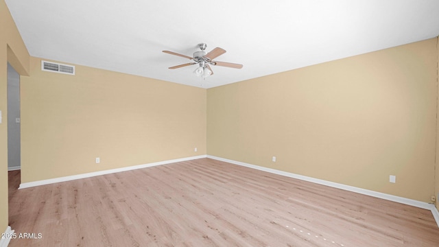 unfurnished room with baseboards, light wood-type flooring, visible vents, and a ceiling fan