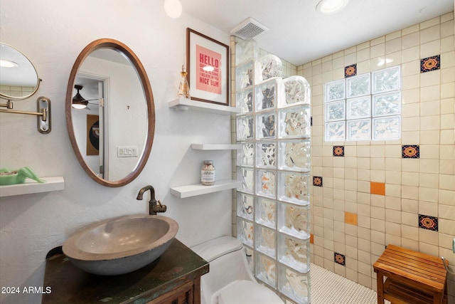 bathroom featuring vanity, toilet, and tiled shower