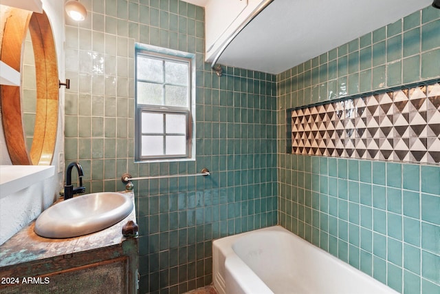 bathroom with vanity, tiled shower / bath combo, and tile walls