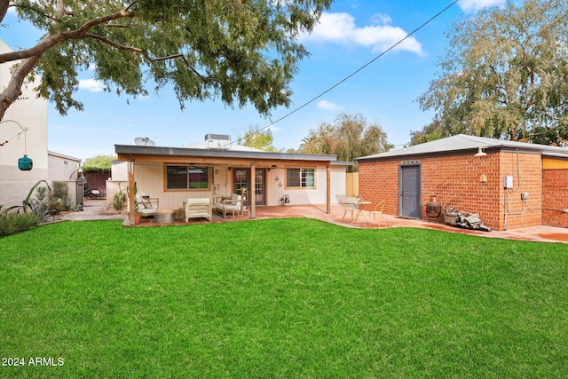 back of property featuring a lawn and a patio