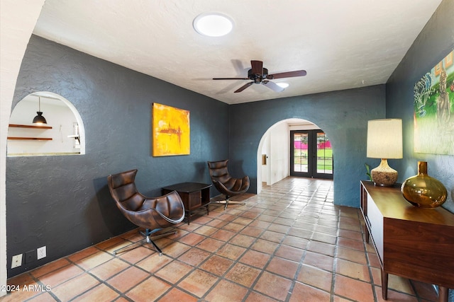 sitting room featuring ceiling fan and french doors