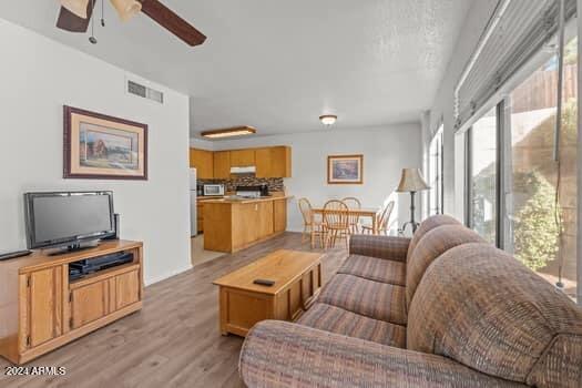 living room featuring light hardwood / wood-style floors and ceiling fan