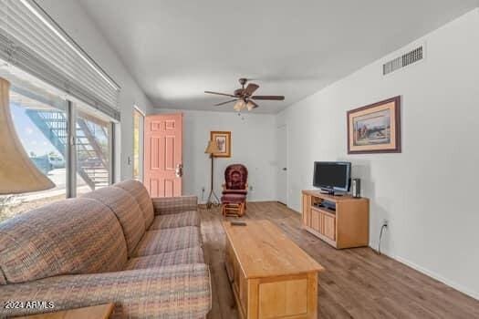 living room featuring hardwood / wood-style floors and ceiling fan