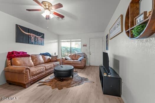 living room featuring light hardwood / wood-style flooring and ceiling fan