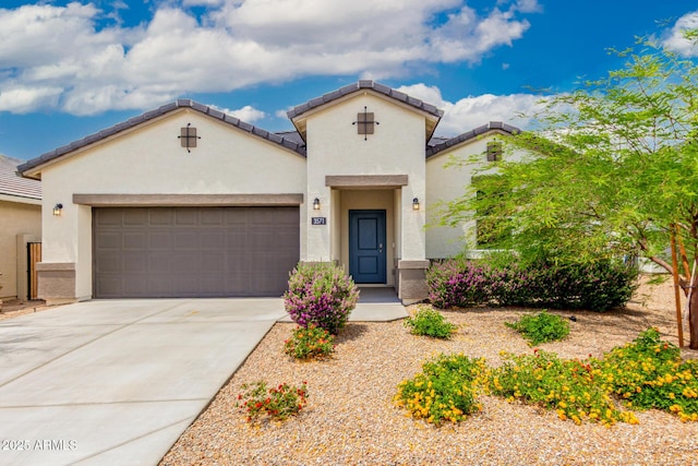 mediterranean / spanish house with stucco siding, a garage, driveway, and a tiled roof