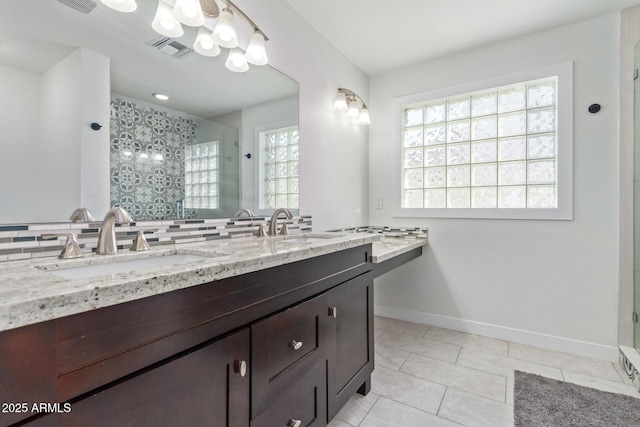 bathroom featuring tile patterned floors, decorative backsplash, vanity, and walk in shower