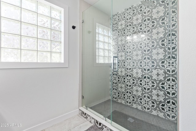 bathroom featuring tile patterned flooring and tiled shower