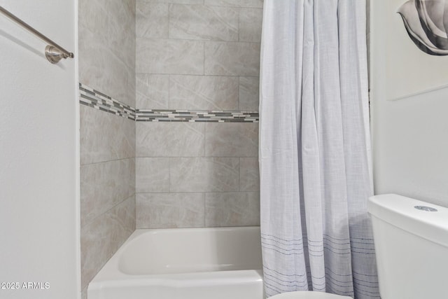 bathroom featuring shower / tub combo and toilet