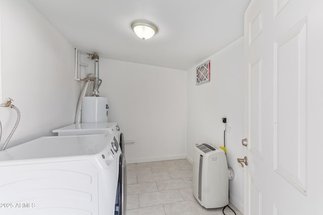 laundry room featuring washer and dryer, gas water heater, and light tile patterned floors