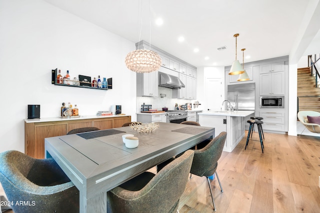 dining space featuring sink and light hardwood / wood-style floors