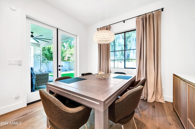 dining area with ceiling fan with notable chandelier and light wood-type flooring