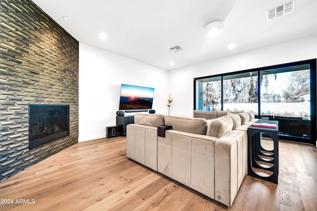 living room with a large fireplace and light hardwood / wood-style flooring