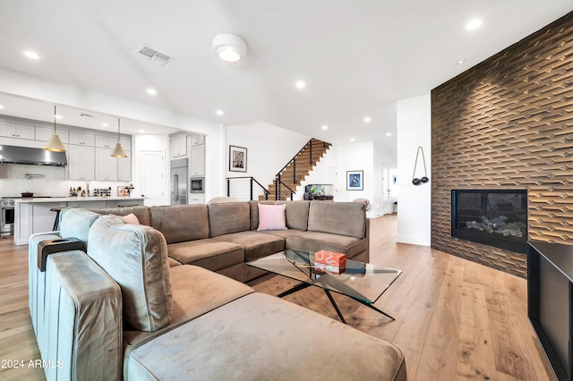 living room with a large fireplace and light hardwood / wood-style floors