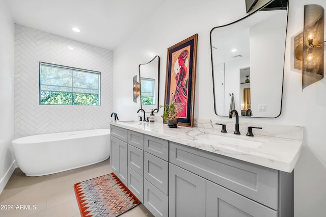 bathroom featuring tile patterned floors, vanity, and a bath