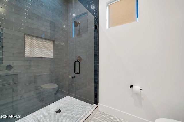 bathroom featuring tile patterned flooring, toilet, and a shower with door