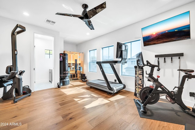 workout area with light wood-type flooring and ceiling fan