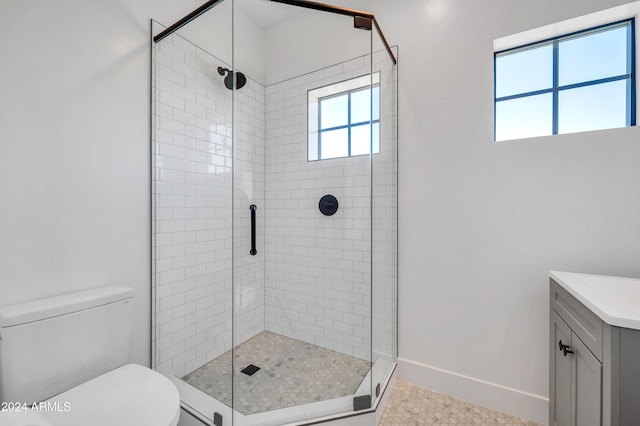 bathroom featuring a shower with door, vanity, and toilet