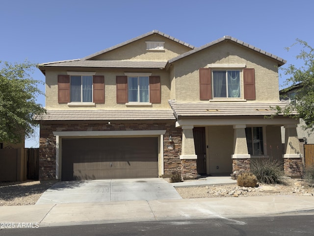 view of front of house with an attached garage, driveway, stucco siding, and stone siding