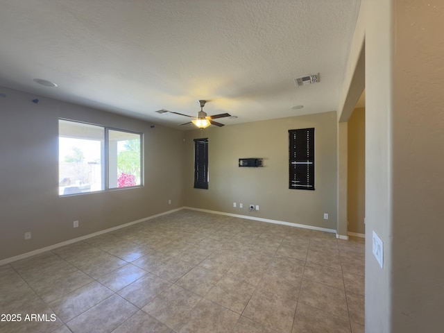 unfurnished room with baseboards, light tile patterned floors, a textured ceiling, a ceiling fan, and visible vents