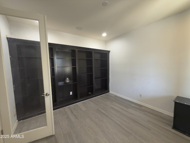 unfurnished room featuring baseboards, recessed lighting, and wood finished floors