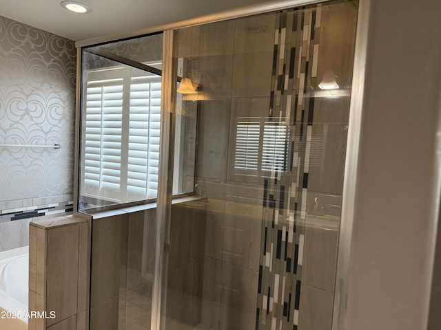 bathroom with a shower stall, plenty of natural light, a garden tub, and wallpapered walls