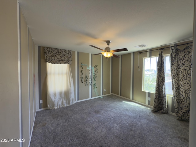 spare room with visible vents, a ceiling fan, and carpet flooring