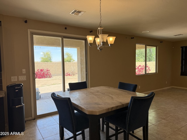 dining space with a notable chandelier, visible vents, baseboards, and light tile patterned flooring