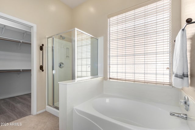 bathroom with tile patterned floors and shower with separate bathtub