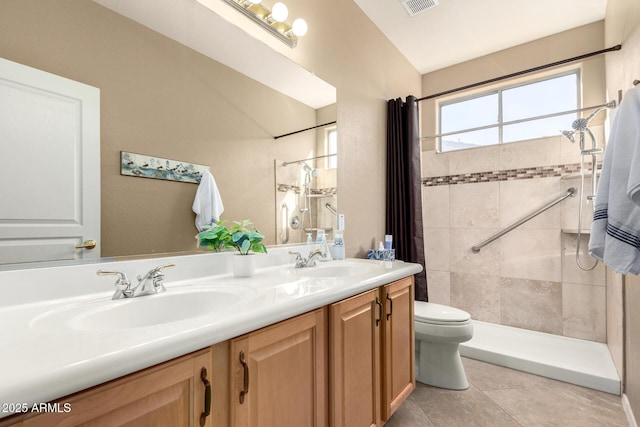 bathroom with toilet, vanity, tile patterned floors, and walk in shower