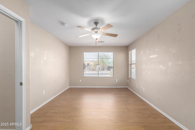 empty room featuring light wood-type flooring and ceiling fan