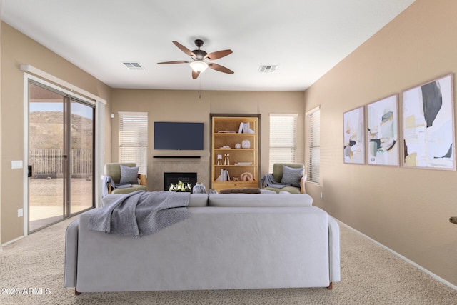 living room with built in features, ceiling fan, and carpet